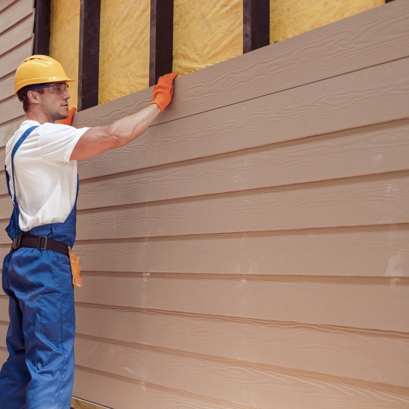 Male worker building house at construction site