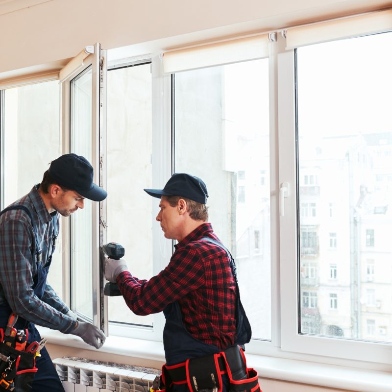 Quality light. Construction workers installing new window in house