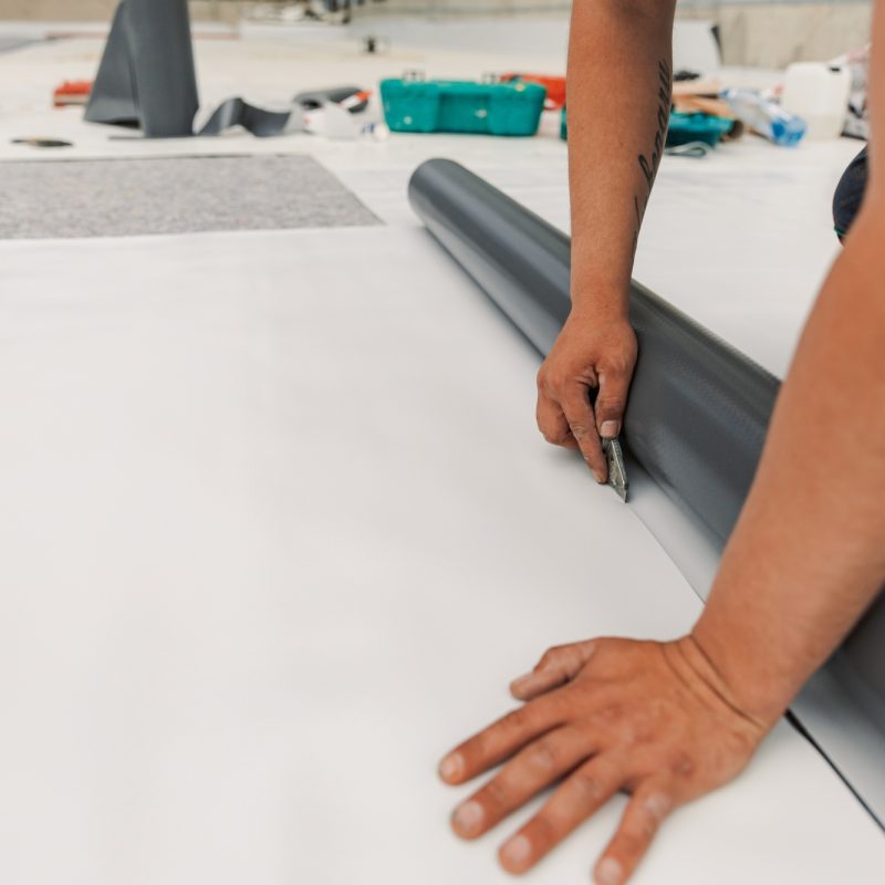 Worker specialized in mounting PVC membranes, TPO in the process of installing a water resistant Worker specialized in mounting PVC membranes, TPO in the process of installing a water resistant